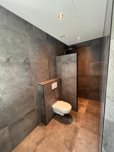 La salle de bains est pourvue d'une douche et de toilettes. dans l'établissement Luxe villa op Vakantiepark de Koorn-aar, à Den Burg