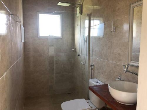 uma casa de banho com um WC, um lavatório e um chuveiro em Aconchegante Chalé - Recanto dos Canários 