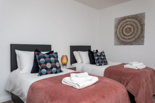 duas camas com toalhas num quarto em Flat 7- Spacious Studio Flat in The Heart of Crawley em Crawley