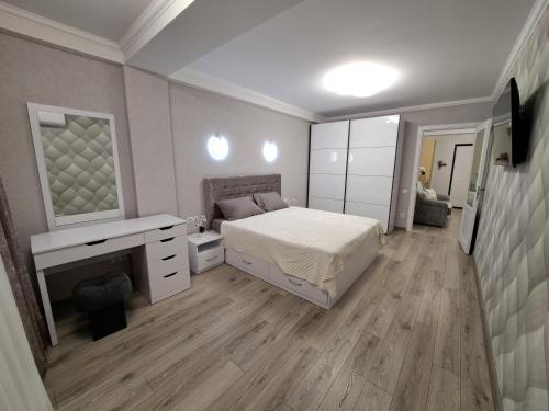 a bedroom with a bed and a desk and a mirror at Decebal in Chişinău