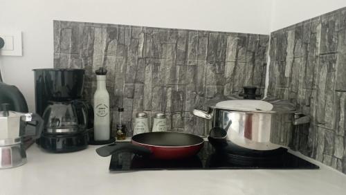 a kitchen counter with a pot on a stove at suite diminutif 2 in Adamas