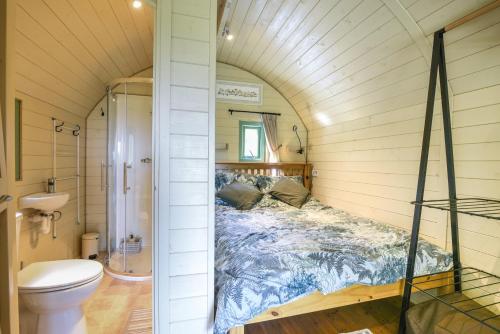 um quarto com uma cama numa pequena casa em Pendragon Pod em Axminster