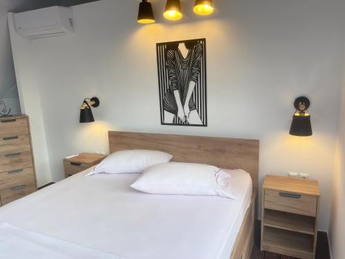 a bedroom with a white bed and a picture on the wall at Ellie's Eco Private Glamping and Spa in Nea Kallikrateia