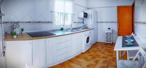 a kitchen with a sink and a washing machine at Chalet Mari Carmen in Chiclana de la Frontera