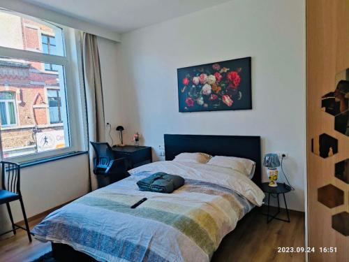 een slaapkamer met een bed en een raam bij SalzinnesChezSoi in Namen