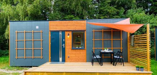una casa pequeña con una mesa y sillas en una terraza en Lomma Camping, en Lomma