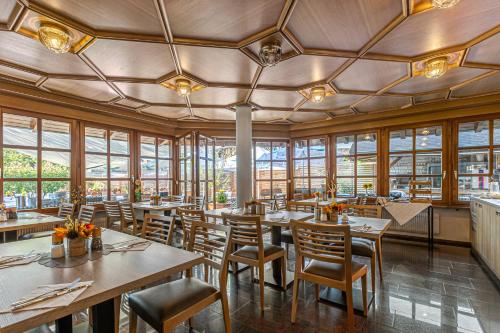 a restaurant with wooden tables and chairs and windows at Zur Blume Hotel & Restaurant Efringen-Kirchen bei Basel in Efringen-Kirchen