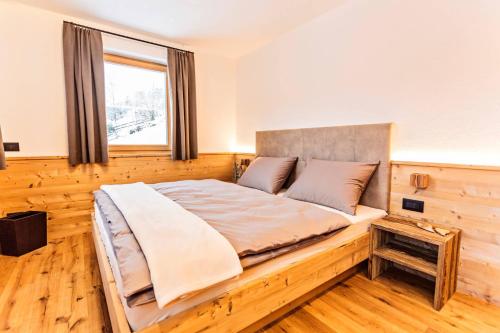 a large bed in a room with a window at Apartments Milanhof in Ortisei
