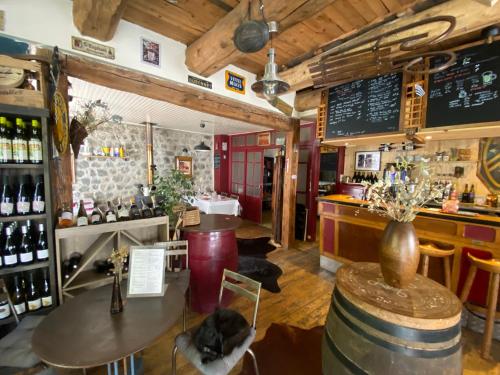 - un bar avec une table et un comptoir avec des bouteilles de vin dans l'établissement Charmant appartement au cœur des volcans d Auvergne, à Murat