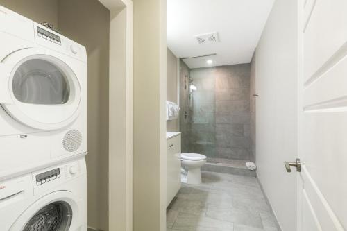 a bathroom with a washing machine and a toilet at Lively 4BR Condo Steps to French Quarter in New Orleans