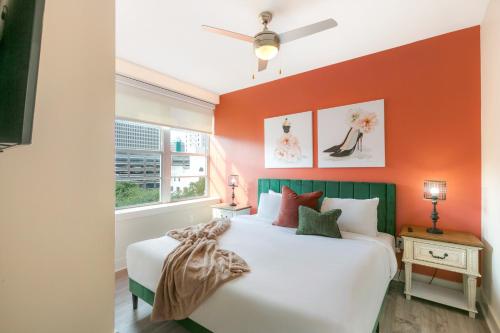 a bedroom with an orange accent wall and a bed at Lively 4BR Condo Steps to French Quarter in New Orleans