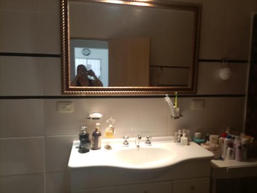 una mujer tomando una foto de un lavabo de baño en CASA RUBIA MORENO, en La Banda