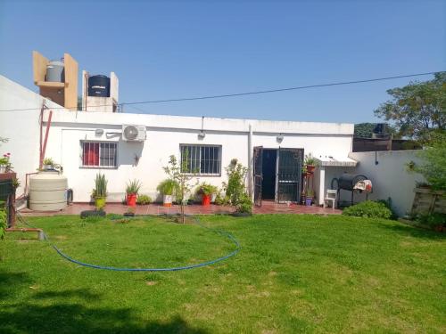 a white house with a hose in a yard at CASA RUBIA MORENO in La Banda