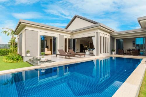 a villa with a swimming pool in front of a house at SEA VILLA HỒ TRÀM in Ho Tram