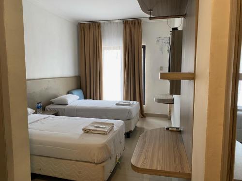 pokój hotelowy z 2 łóżkami i stołem w obiekcie Belvena Makati Hotel w mieście Sukarami