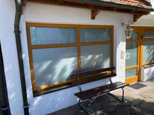 eine Bank, die vor einem Gebäude mit einem Fenster sitzt in der Unterkunft Auszeit am Gehrenberg in Markdorf