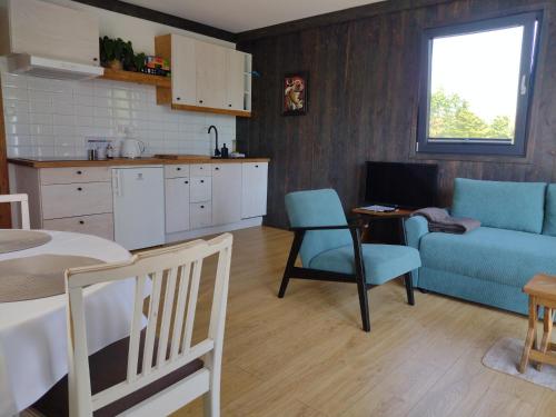 a kitchen and living room with a couch and a table at Domek Letniskowy ZŁOTY KARAŚ in Widna Góra