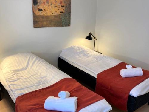 twee bedden naast elkaar in een kamer bij Kotimaailma - Kodikas kaksio saunalla Matinkylässä in Espoo