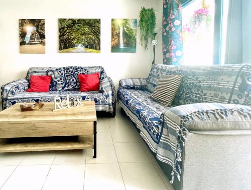 a living room with two couches and a coffee table at Casita Mara! 2’ Line to the sea, shops and bar’s in Tías