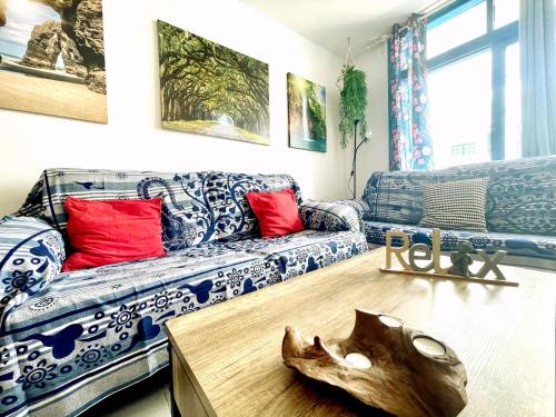 a living room with a couch and a wooden table at Casita Mara! 2’ Line to the sea, shops and bar’s in Puerto del Carmen