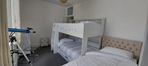 two bunk beds in a room with a camera at A home away from home in Torquay