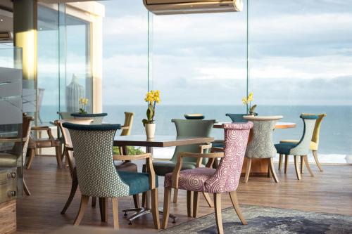 a dining room with a table and chairs and the ocean at Views Boutique Hotel & Spa in Wilderness