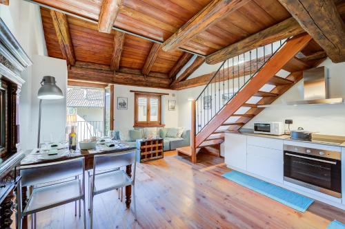 Il comprend une cuisine dotée de plafonds en bois et un salon. dans l'établissement San Marco Lodge Apt Mountain Retreat - Happy Rentals, à Oulx