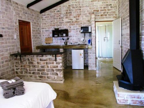 a living room with a brick wall and a fireplace at Stonefly Cottages in Dullstroom