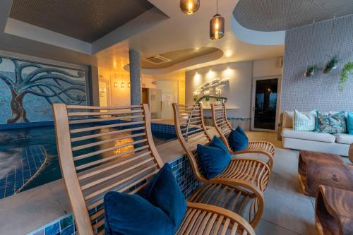 a room with three chairs and a swimming pool at Views Boutique Hotel & Spa in Wilderness