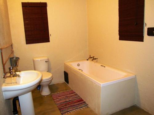 a bathroom with a toilet and a tub and a sink at Stonefly Cottages in Dullstroom