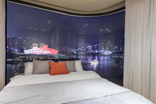 a bedroom with a large window with a view of a city at Baihong Riverview Apartment-Hongya Cave in Chongqing