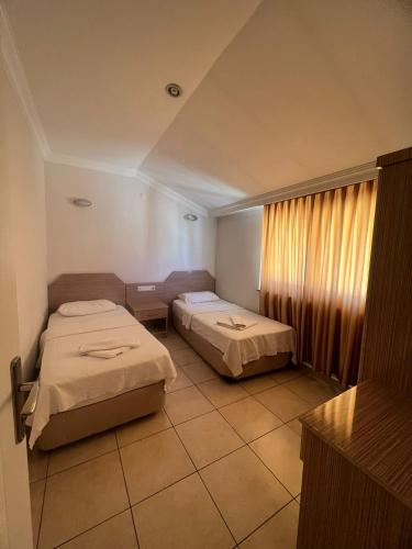 a hotel room with two beds and a window at Safran Apart Hotel in Alanya