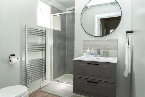 ein Bad mit einer Dusche, einem Waschbecken und einem Spiegel in der Unterkunft Montpellier Villa 