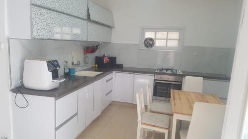 a kitchen with white cabinets and a table and a counter top at arad rooms & apartments חדרי אירוח ערד in Arad