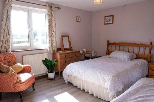 1 dormitorio con cama, silla y espejo en Marsh Farm en Bridgwater