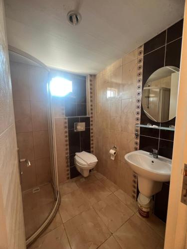 a bathroom with a toilet and a sink and a shower at Safran Apart Hotel in Alanya