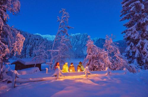 a group of four people sitting in the snow at night at Ferienhaus Jäger in Oetz