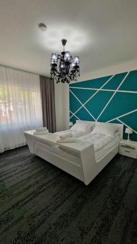 Un dormitorio con una cama grande y una lámpara de araña. en BTP House en Hunedoara