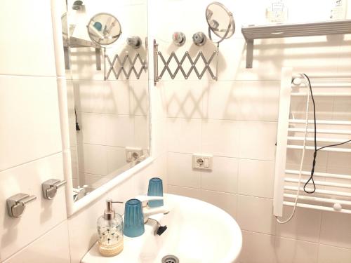 Baño blanco con lavabo y espejo en Apartamento * Estudio Orobanca, en Santa Brígida