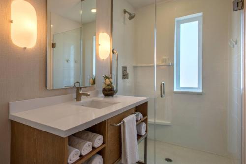 y baño con lavabo y ducha. en SpringHill Suites by Marriott San Diego Oceanside/Downtown en Oceanside