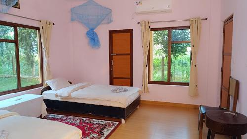 Mr. B's Place في Bhurkīā: غرفة نوم بسريرين وطاولة ونوافذ