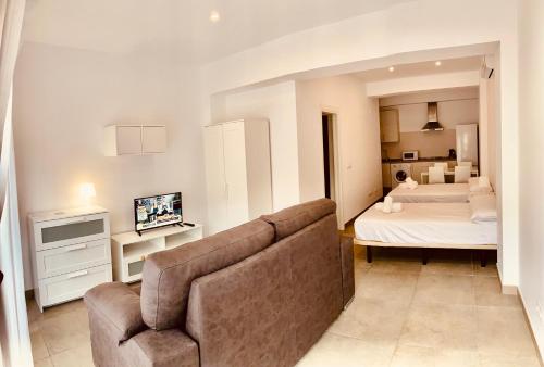 sala de estar con sofá y dormitorio en Apartamentos Pintor Losada en Córdoba