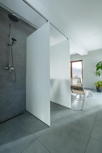 a white bathroom with a shower and a chair at Willa Żar in Bialskie