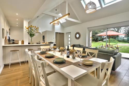 une salle à manger et une cuisine avec une table et des chaises dans l'établissement La longère de Poulrinou, à Bohars