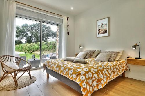 1 dormitorio con cama y ventana grande en La longère de Poulrinou en Bohars