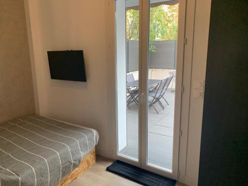 a room with a bed and a sliding glass door at Cassis grande terrasse emplacement au top à 1 minute de la plage à pieds in Cassis