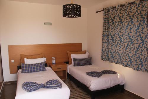 a room with two beds with bows on them at Dakhla Camp in Dakhla