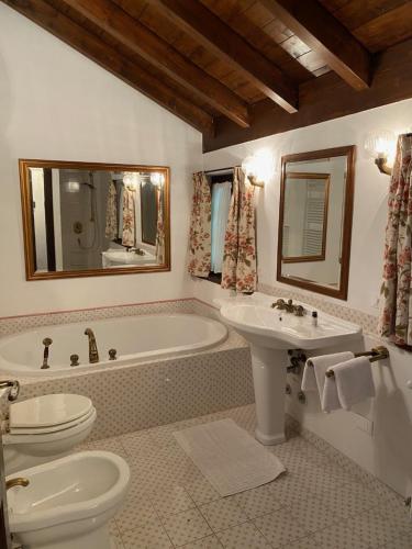 ein Badezimmer mit einer Badewanne, einem WC und einem Waschbecken in der Unterkunft Chalet Miralago in Plesio
