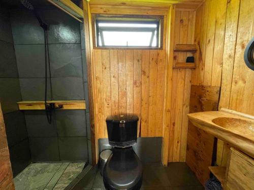 a small bathroom with a shower and a sink at Tiny Catamarán in Cobquecura
