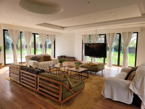 a living room with couches and a flat screen tv at Maison 12 personnes, Vendée et puy du fou in Treize-Septiers